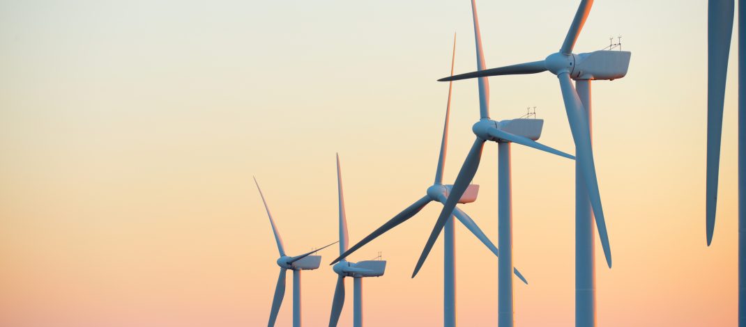Wind turbine generators for sustainable electrical energy production at sunrise Stock Image