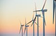 Wind turbine generators for sustainable electrical energy production at sunrise Stock Image