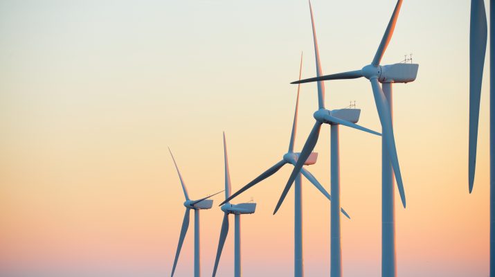 Wind turbine generators for sustainable electrical energy production at sunrise Stock Image